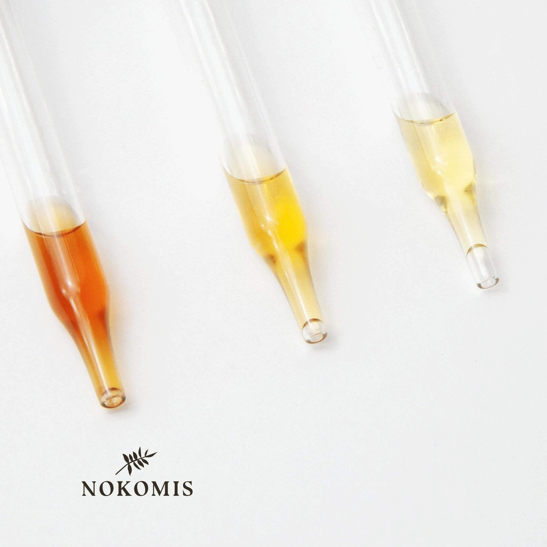 Close-up of a green glass dropper and a brown bottle on a white background with a green leaf. Highlights natural skincare, eco-friendly beauty, and organic wellness products